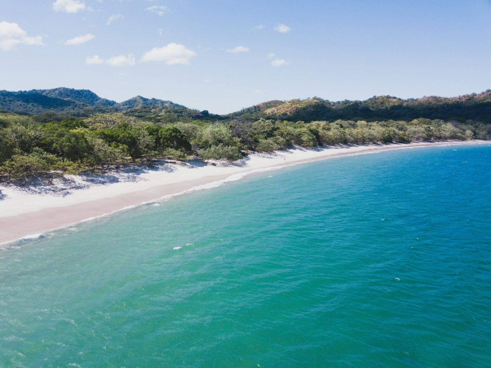 Aerial view of a pristine Guanacaste beach with turquoise water and white sand